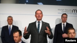 Richard Grenell, center, U.S. special envoy to Belgrade-Pristina talks; Kosovo's President Hashim Thaci, standing left; and Serbia's President Aleksandar Vucic, standing right, attend the Munich Security Conference in Germany, Feb. 14, 2020.