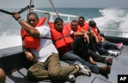 FILE - En route to a processing center on mainland Puerto Rico about three hours away, Cuban migrants picked up earlier on Puerto Rico's remote Mona Island sit on the deck of a U.S. Border Patrol boat.