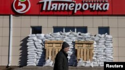 A man walks by a fortified Pyaterochka supermarket in Belgorod, Russia, on March 11, 2024.