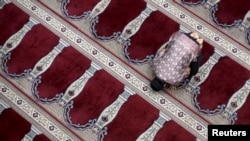 FILE - A man prays at the Cut Meutia Mosque in Jakarta, Indonesia.