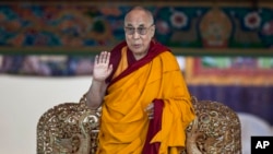 FILE - Tibetan spiritual leader the Dalai Lama gestures to devotees before he starts teaching on the fifth day of Kalachakra near Leh, India.
