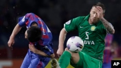 Matic Darko de Beijing Guoan de la Chine, à droite, devance Takuji Yonemoto du FC Tokyo du Japon dans un duel pour la balle lors d’un match de football pour la qualification de la Ligue des champions de l'AFC 2012 à Tokyo, 17 avril 2012. 