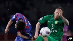 Matic Darko de Beijing Guoan, à droite, devance Takuji Yonemoto du FC Tokyo lors d'un match de qualification en Ligue des champions de l'AFC, Tokyo, le 17 avril 2012. 