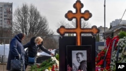 La madre del opositor ruso Alexei Navalny, Lyudmila Navalnaya (izquierda), y la suegra visitan su tumba un día después de su entierro, en el cementerio Borisovskoye, en Moscú, Rusia, el 2 de marzo de 2024.
