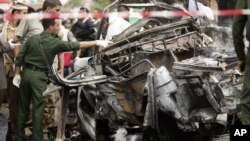 Forensic policemen collect evidence at the site of a car bomb attack targeting the motorcade of the country's defense minister in Sanaa, Yemen, September 11, 2012.