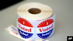 FILE - A spool of stickers rests on a table at a polling station during Massachusetts state primary voting, Sept. 3, 2024, in Newton, Mass.