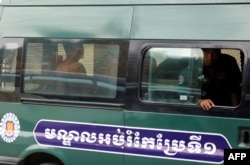 Yeang Sothearin and Uon Chhin, former journalists for U.S. founded Radio Free Asia (RFA), who have been charged with espionage, sit inside a police vehicle as they arrive for a bail hearing at the Appeals Court in Phnom Penh, Cambodia, April 19, 2018.