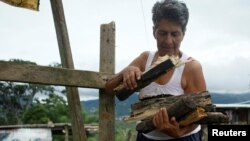 Maria Garcia carries firewood at her house in San Cristobal, Venezuela, Aug. 5, 2017. 