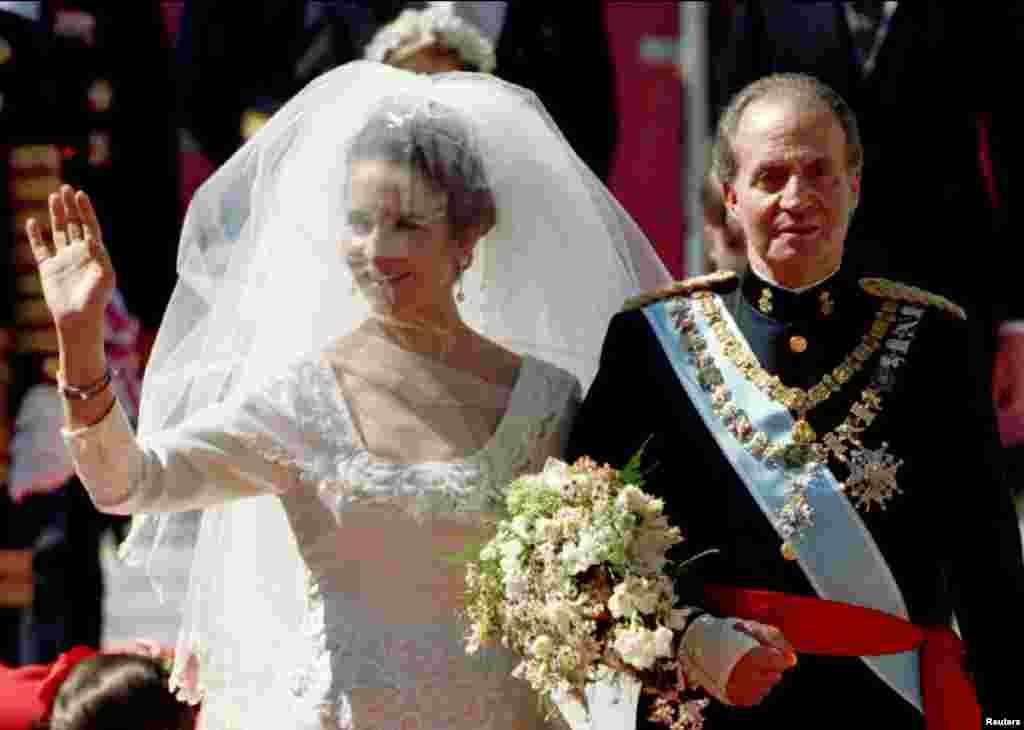 Spain's Princess Elena waves to the crowds as she is escorted by her father King Juan Carlos to the altar of Seville's cathedral on March 18, 1995.