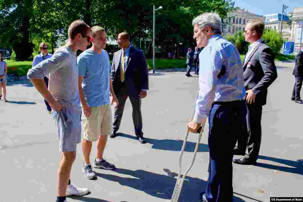 جان کری وزیر خارجه آمریکا در پارک نزدیک به هتل کوبورگ وین در حال گفتگو با دو جوان آمریکایی -۳ ژوئیه ۲۰۱۵ 