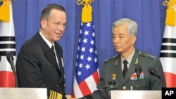 U.S. Navy Adm. Mike Mullen, left, the U.S. chairman of the Joint Chiefs of Staff, and South Korean Gen. Han Min-Koo, right, chairman of South Korean Joint Chiefs of Staff shake hands after their joint press conference at the Defense ministry in Seoul, De