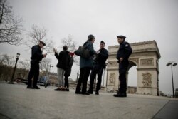 Police officers control on the Champs-Elysees avenue in Paris, March 17, 2020.