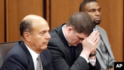 Cleveland police officer Michael Brelo, center, listens to the judge reading his verdict during his trial in Cleveland, Ohio, May 23, 2015.