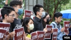 台港青年学生团体5月28日在台北的香港经贸办事处前举牌呼吁：“恶法压境齐心共进”、“防疫当前也要上学”。（美国之音李玟仪摄）