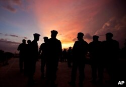 FILE - This photo shows silhouettes of U.N. peacekeepers from Brazil at the airport in Port-au-Prince, Haiti, July 11, 2011. According to an AP investigation, some 150 allegations of abuse and exploitation were reported in Haiti between 2004 and 2016. The allegations involved U.N. peacekeepers and other personnel.