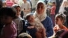 (FILE) A displaced Palestinian mother carries her daughter Lynn as she waits to get her vaccinated against polio, in Deir Al-Balah, in the central Gaza Strip September 1, 2024.