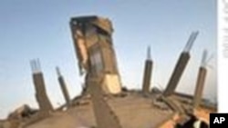 Wata mace tana wucewa gaban wani gida da Isra'ila ta rusa a  wani sumame da ta kai a Zirin Gaza.
