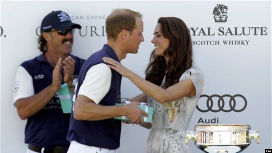 Kate, Duchess of Cambridge, memberikan tropi bagi tim pemenang pertandingan polo sebelum memberi kecupan kepada suaminya, di lapangan polo Santa Barbara, Carpinteria, Kalifornia (10/7).