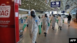 FILE - Navy soldiers are seen after carrying out a disinfection operation against the novel coronavirus COVID-19 at Tom Jobim Galeao International Airport in Rio de Janeiro, Brazil, on April 24, 2020. 