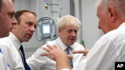 Britain's Prime Minister Boris Johnson, center, visit Pilgrim Hospital in Boston, northeast England, Aug. 5, 2019.