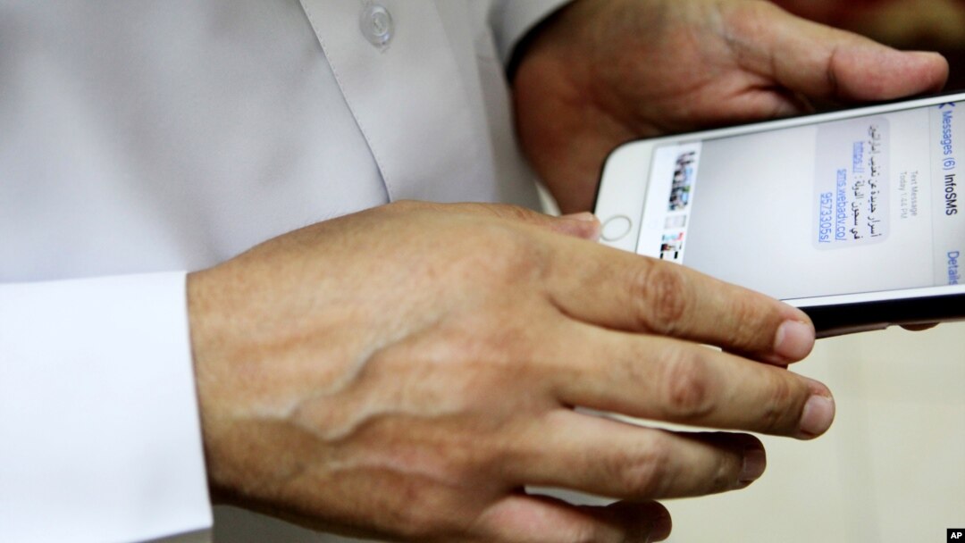 FILE - Human rights activist Ahmed Mansoor shows Associated Press journalists a screenshot of a spoof text message he received in Ajman, United Arab Emirates, Aug. 25, 2016. Mansoor was recently targeted by spyware that can hack into Apple's iPhone.