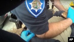 In this image taken from Alameda Police Department body camera video, Alameda Police Department officers pin 26-year-old Mario Gonzalez to the ground during an arrest, April 19, 2021, in Alameda, Calif. Gonzalez stopped breathing during the arrest…