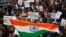 Indian students wave an Indian flag and shout slogans during a protest at the Jawaharlal Nehru University against the arrest of a student union leader in New Delhi, India, Thursday, Feb. 18, 2016.