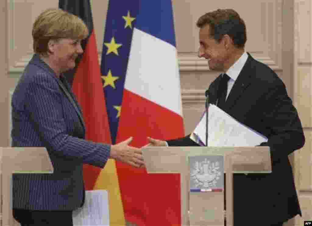 German Chancellor Angela Merkel, left, and France's President Nicolas Sarkozy, right, shake hands after their joint press conference at the Elysee Palace, Tuesday Aug. 16, 2011. (AP Photo/Michel Euler)