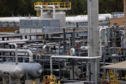 FILE - Tanks and pipes move product through the MarkWest Bluestone Gas Processing Plant in Evans City, Pa., Oct. 17, 2019.