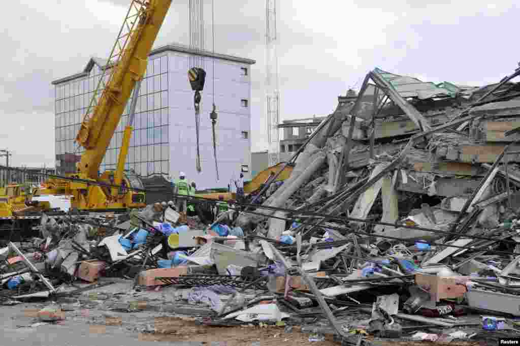 Rescue workers look for survivors from the debris of a collapsed building, Accra, Ghana, November 7, 2012.