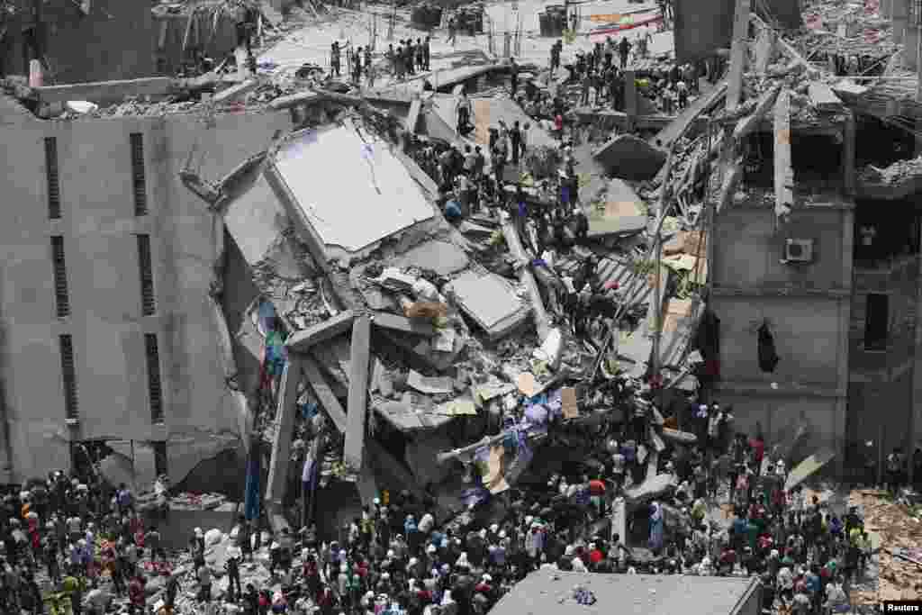 People rescue garment workers trapped under rubble at the Rana Plaza building after it collapsed, in Savar, 30 km (19 miles) outside Dhaka, Bangladesh. An eight-story block housing garment factories and a shopping center collapsed on the outskirts of the capital, killing at least 70 people and injuring hundreds.