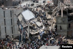 Petugas menyelamatkan para pekerja yang terperangkap di bawah reruntuhan gedung Rana Plaza di Savar, Bangladesh, 24 April 2013.