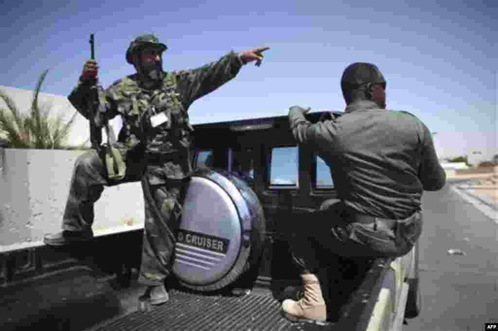 Rebel fighters talk to each other at the town of Brega, Libya, Monday, Aug. 15, 2011. Most of the town has been liberated from Moammar Gadhafi's forces, with fights going on only at the oil terminal, according the rebel military spokesman, Ahmed Bani (AP
