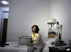 FILE - Chinese Human rights activist Ni Yulan sits on the bed in a hotel in Beijing. She has been barred by Beijing from traveling to Washington.