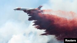 A plane drops fire-retardant chemicals on the 416 Fire near Durango, California, in this June 9, 2018, handout photo. 