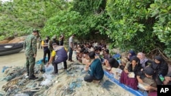 Anggota angkatan laut Thailand membantu pengungsi Rohingya yang ditemukan di Pulau Koh Dong di Provinsi Satun, Thailand selatan. (Foto: via AP)