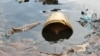 FILE - Crude oil from a Shell pipeline spill accumulates along a bank in the Niger Delta, Nov. 27, 2014. Advocacy groups are calling on Shell to halt its plans to divest assets from Nigeria's Niger Delta region unless cleanup and decommissioning of its infrastructure is complete.