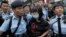 A protester is taken away by police officers after the confrontation between activists demonstrating against mainland Chinese shoppers and local villagers at a suburban district of Yuen Long in Hong Kong, Sunday, March 1, 2015.