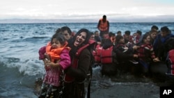 A woman screams for help after she and her daughter fell in the water as they arrive along the northeastern Greek island of Lesbos, Oct. 2 , 2015. 