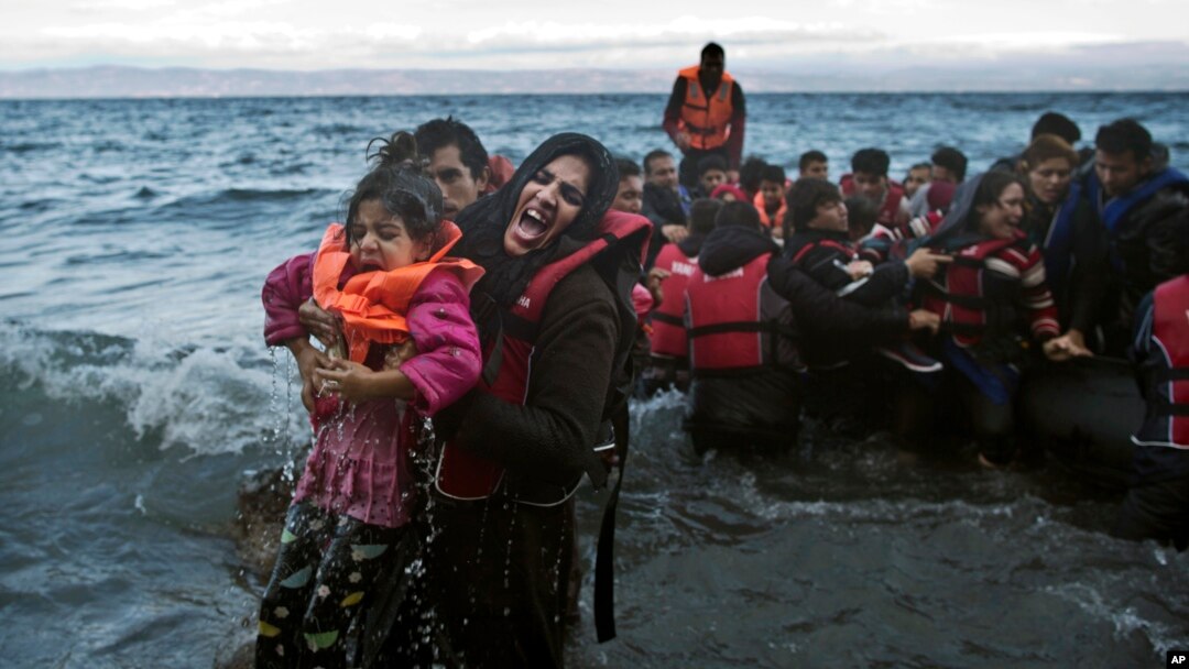 Seorang perempuan berteriak minta tolong saat dia dan anaknya tercebur ke laut, setibanya di pulau Lesbos, Yunani (2/10). 
