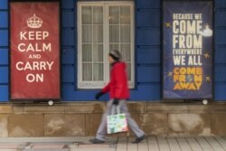 FILE - A woman walks past the Royal Alexandra Theatre in Toronto, Ontario, March 24, 2020.