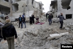 FILE - Residents inspect a crater at a site hit by what activists said were three consecutive airstrikes carried out by the Russian air force, the last which hit an ambulance, in the rebel-controlled area of Maaret al-Numan town in Idlib province, Syria, Jan. 12, 2016.