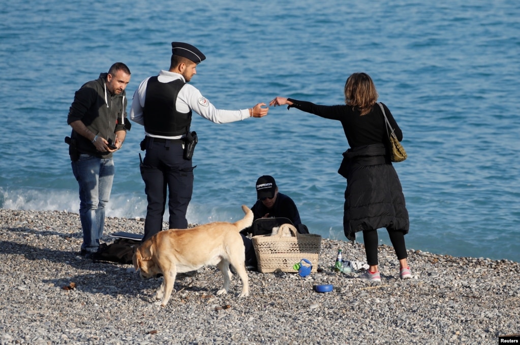 Oficiales de policía controlan a los transeúntes en la playa de la Promenade des Anglais en Niza, ya que se impone un bloqueo para reducir la tasa de la enfermedad por coronavirus (COVID-19) en Francia.