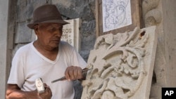 Master stone carver Tomás Ugarte sculpts quarry at the cemetery in the Mexico City borough of Chilmalhuacan, once the ancient village of Xochiaca, Sunday, July 2, 2023. (AP Photo/Aurea Del Rosario)
