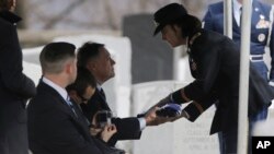 Le colonel Cindy Jebb, à droite, présente un drapeau au général- major David Strong lors d'un service funéraire au cimetière de West Point, à West Point, NY, 22 mars 2013.