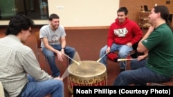 Native American students drum and sing together in a ceremony at the University of Wisconsin-Madison.