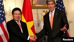 U.S. Secretary of State John Kerry (R) shakes hands with Vietnamese Deputy Prime Minister and Foreign Minister Pham Binh Minh before a working lunch at the State Department in Washington, October 2, 2014.