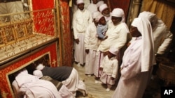 Des chrétiens du Nigeria prient dans la grotte de l'église de la Nativité, traditionnellement considéré par les chrétiens comme le lieu de naissance de Jésus-Christ, dans la ville de Bethléem en Cisjordanie, 24 décembre 2012.