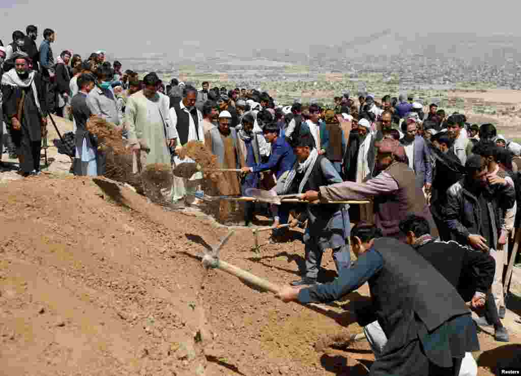 Men dig graves for the victims of yesterday&#39;s explosion during a mass funeral ceremony in Kabul, Afghanistan, May 9, 2021.