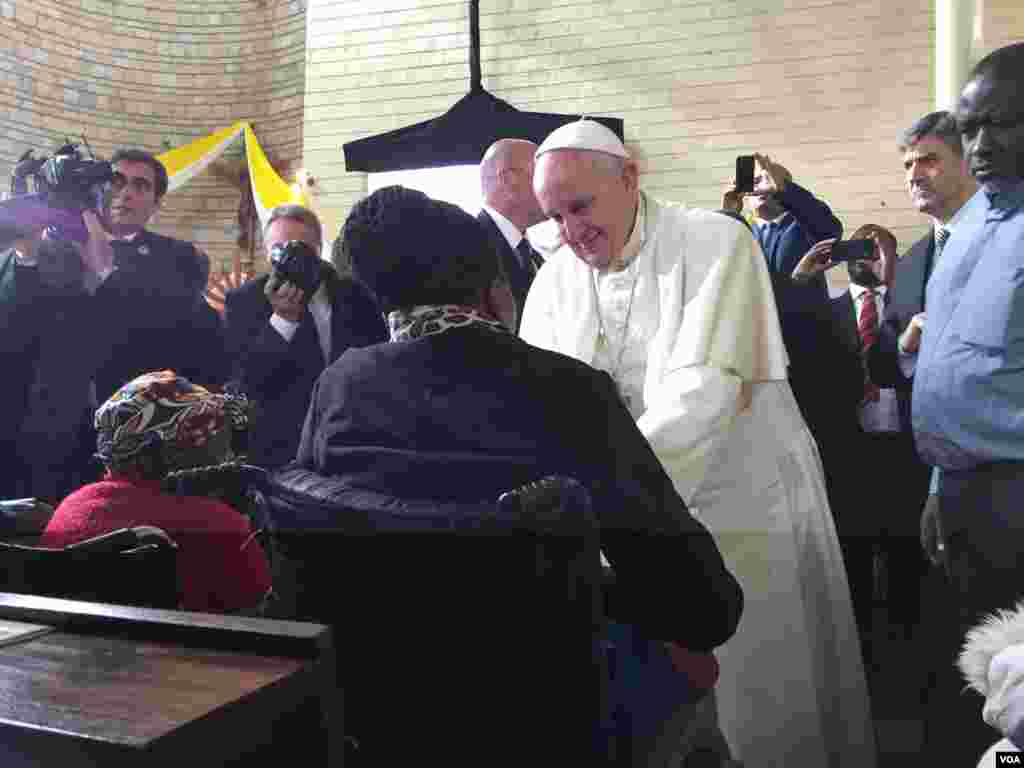 The Pope greeting a woman in a wheelchair at the event in Kangemi, Nov. 27, 2015. (J. Craig/VOA)